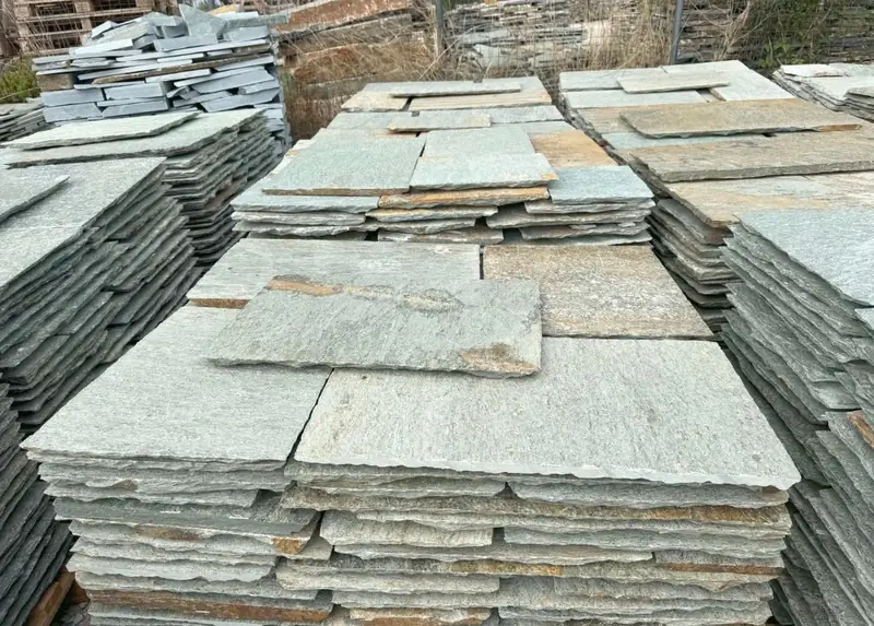 Grau-grüne Pelion-Platten auf Paletten im Steinlager
