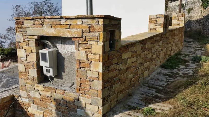 Ochre rust cladding wall electrical meter niche — PelionStones.gr