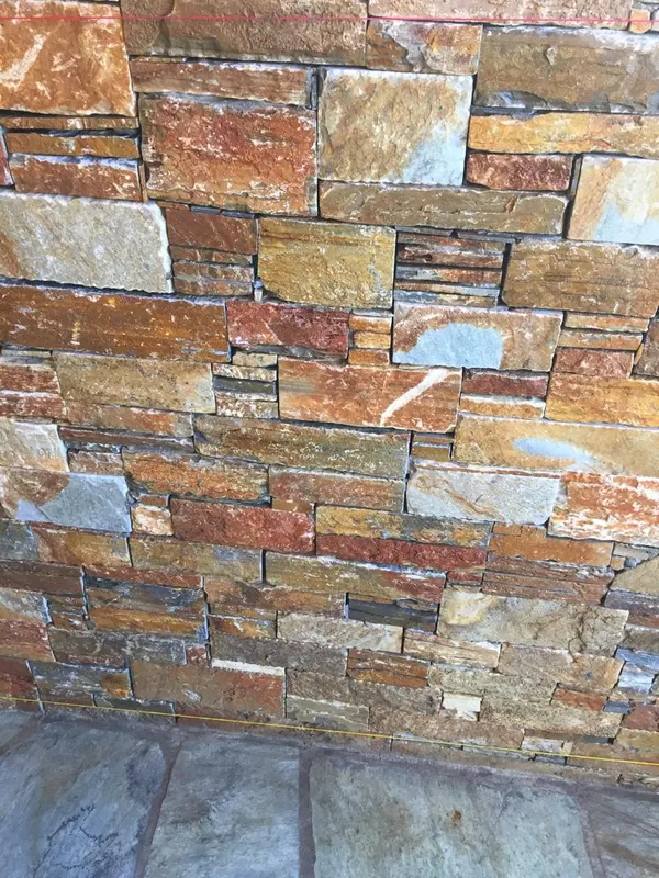 Ochre rust Wandverkleidung above grey flagstone — PelionStones.gr
