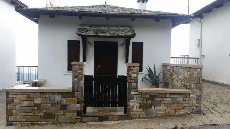 White villa ochre pillars slate awning Holztor — PelionStones.gr
